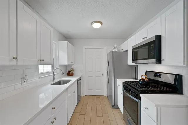 a kitchen with a sink a stove and refrigerator