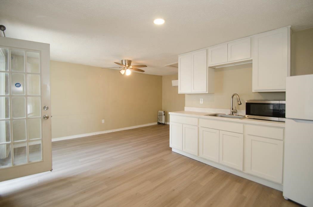 4572 Princeton Road Memphis, TN 38117 - Photo 22 of 24 Kitchen with light countertops, freestanding refrigerator, white cabinetry, ceiling fan, and stainless steel microwave