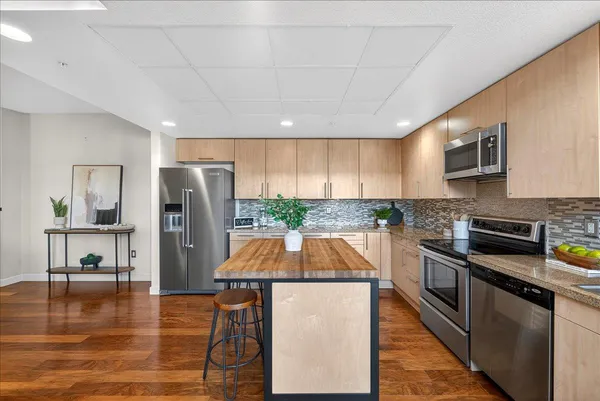 a kitchen with stainless steel appliances a refrigerator a stove a microwave a sink and cabinets