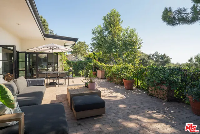 a view of a patio with couches and table and chairs with wooden fence