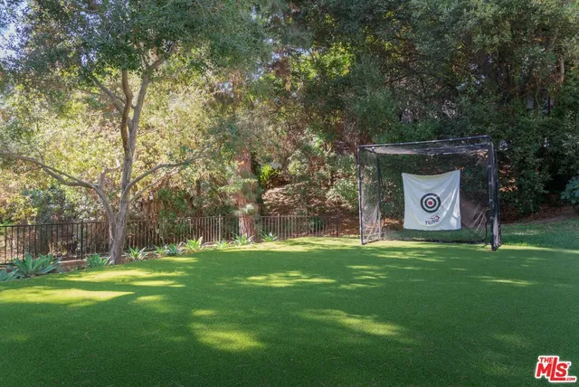 a sign that is sitting in the grass near a tree