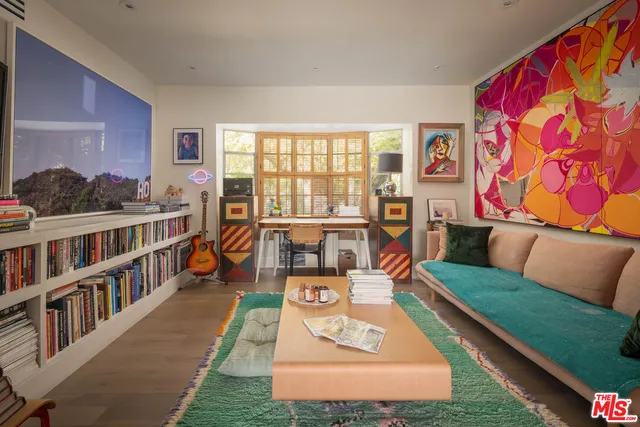 a living room with furniture and a book shelf