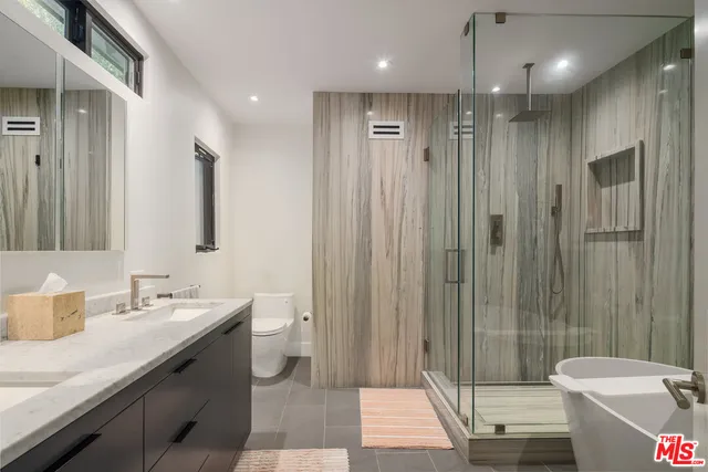a bathroom with a double vanity sink toilet and shower
