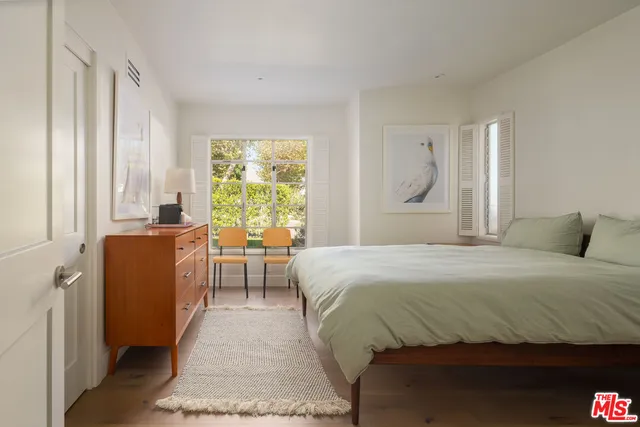 a bedroom with a bed and a large window