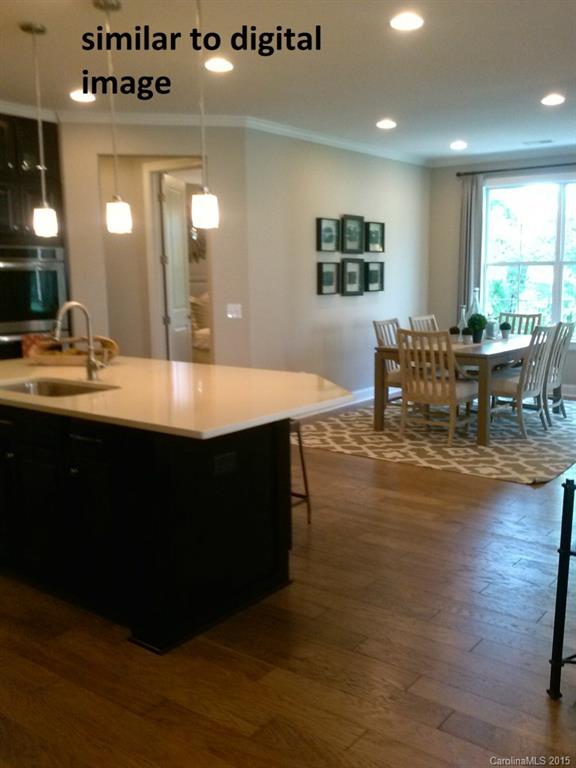 300 Helton Lane, Unit 7 Fort Mill, SC 29708 - Photo 3 of 8 a dining hall with granite countertop a stove a sink a dining table and chairs