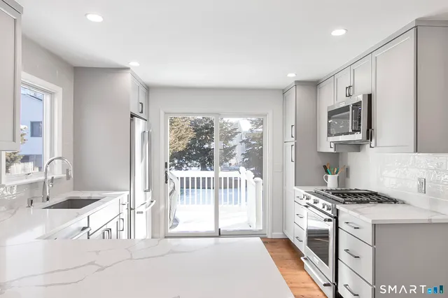 a kitchen with stainless steel appliances a sink and a refrigerator