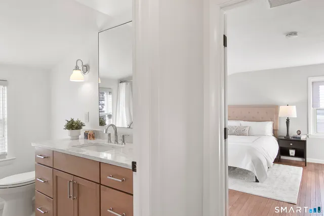 a bedroom with two beds and wooden floor