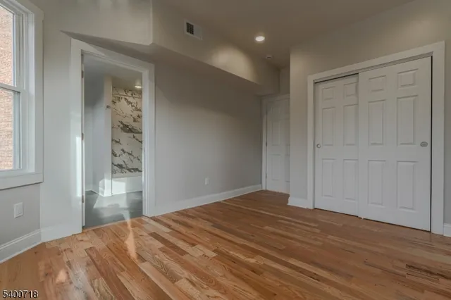 a view of empty room with wooden floor