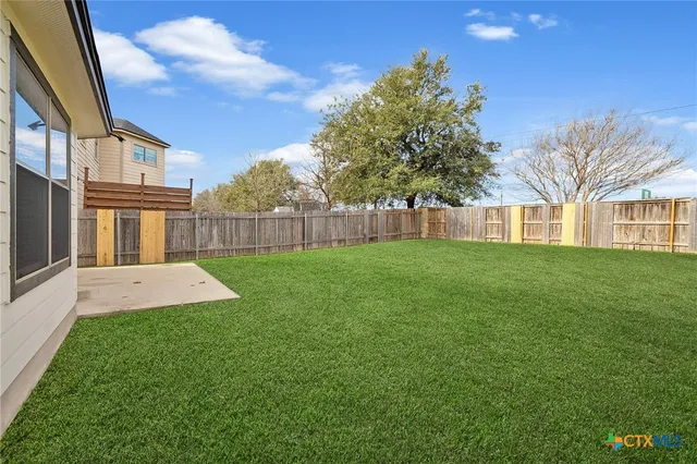 a view of a yard with a house in the background