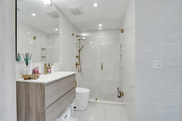 a bathroom with a sink vanity mirror and toilet