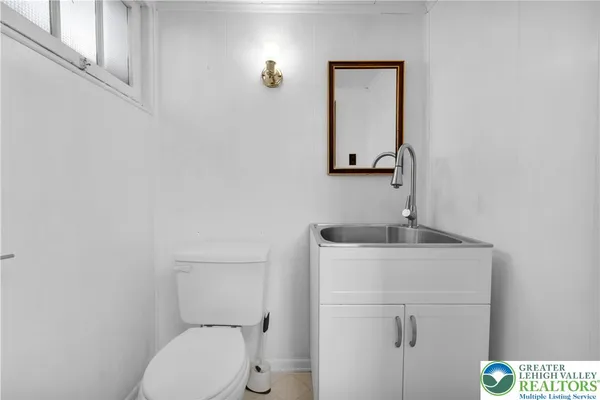 a bathroom with a toilet a sink and mirror