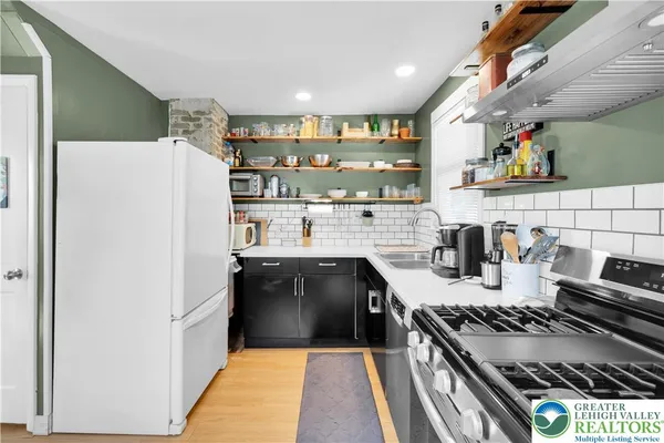 a kitchen with stainless steel appliances granite countertop a stove and a refrigerator
