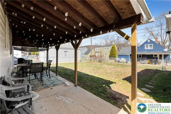 a view of a patio with table and chairs with wooden floor and fence