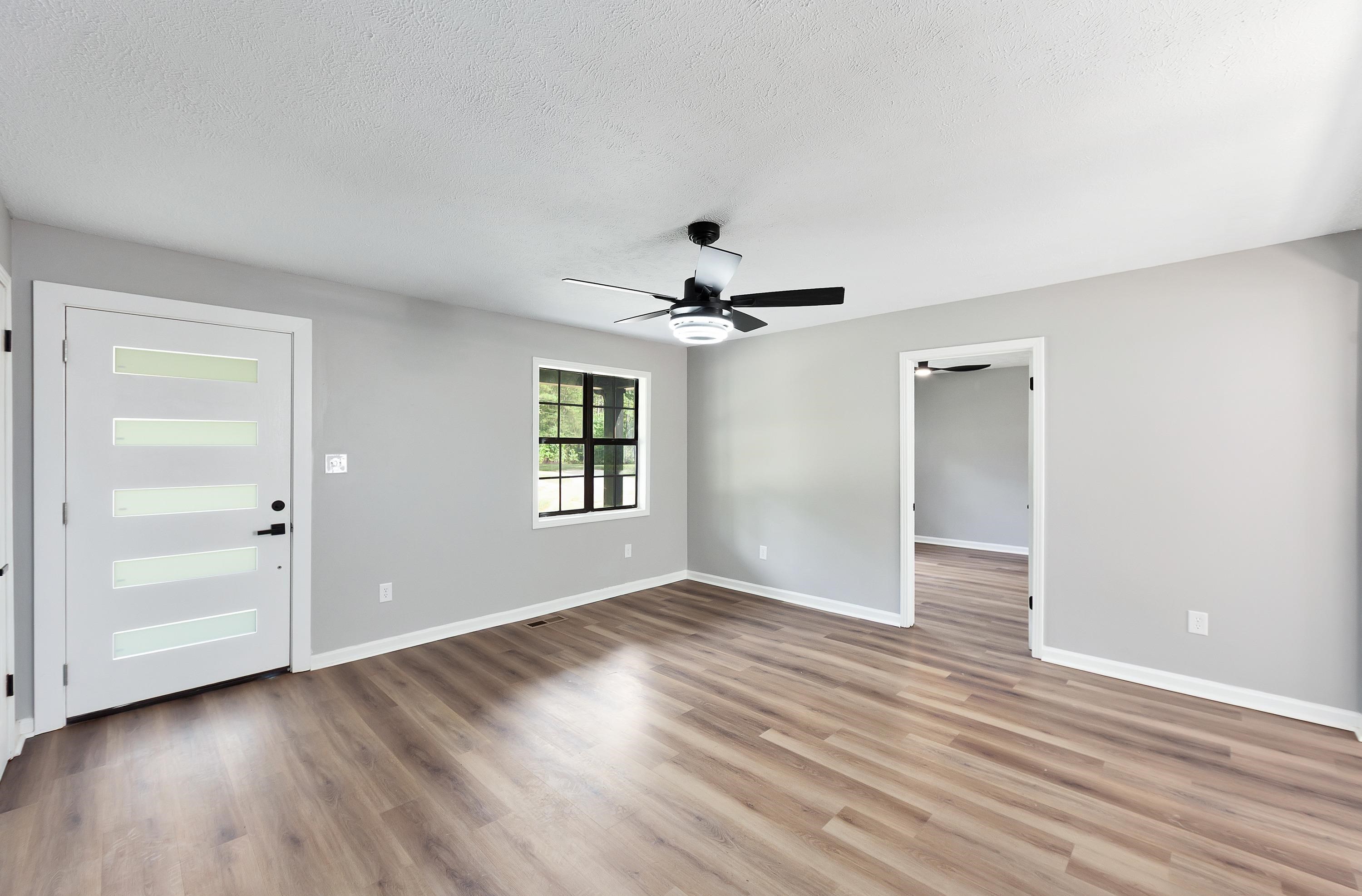 3690 Callahan Road Middleton, TN 38052 - Photo 21 of 26 Wood-finish flooring, light gray wall tones, ceiling fan, contemporary paneled entry door with frosted inserts, black-framed window