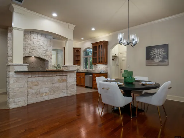 a dining room with furniture a chandelier and wooden floor