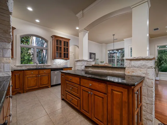 a kitchen with granite countertop a sink and cabinets