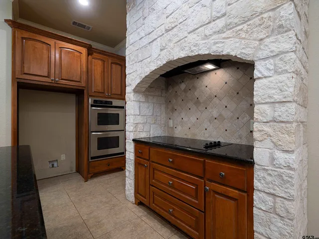 a view of kitchen with stainless steel appliances granite countertop cabinets and window