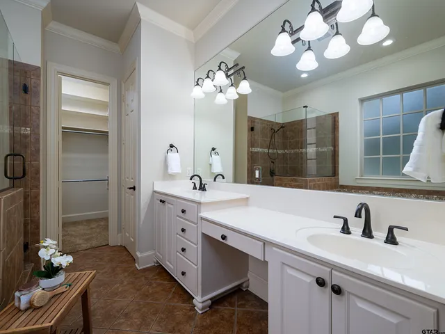 a spacious bathroom with a granite countertop sink a light fixture and a mirror