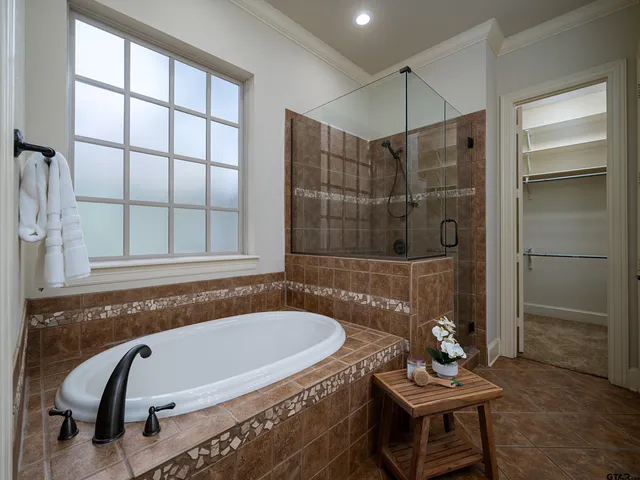 a bathroom with a tub a sink and a window
