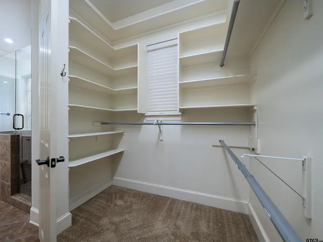 a view of walk in closet with empty racks