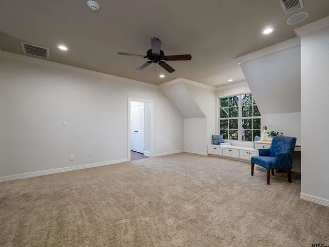 an empty room with windows and ceiling fan