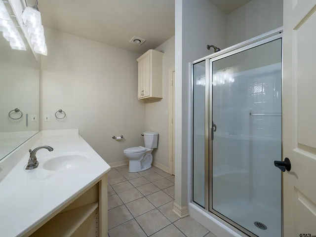 a bathroom with a sink and mirror with toilet