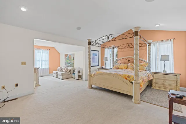 a bedroom with a bed couch and a large window