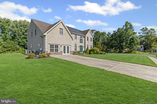 a front view of a house with a yard and trees