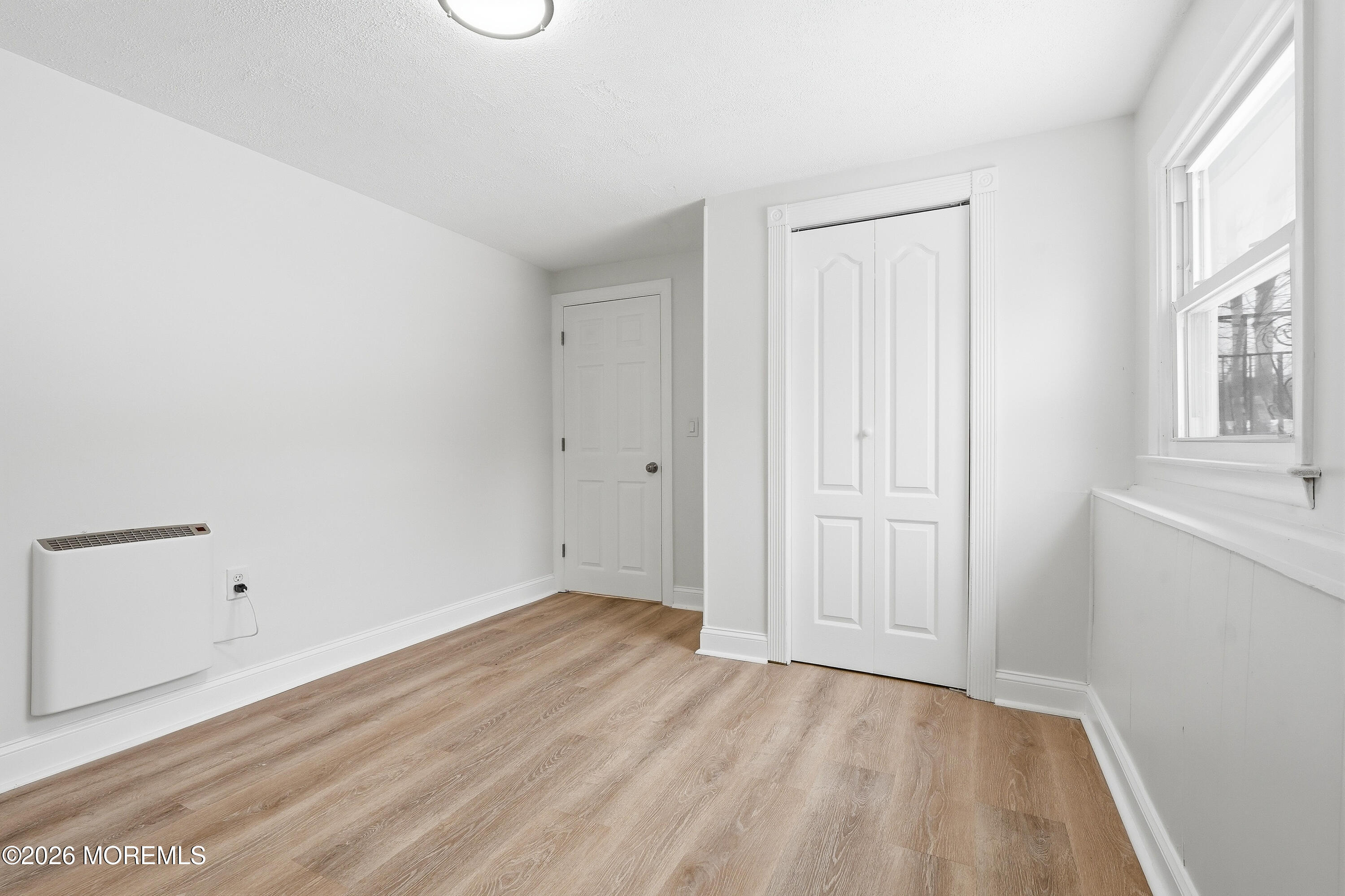 16 Crest Road Jackson, NJ 08527 - Photo 3 of 56 a view of an empty room with wooden floor and a window