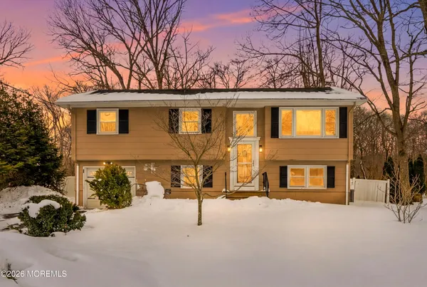 a front view of a house with a yard covered in snow