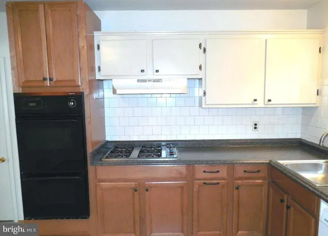 a kitchen with stainless steel appliances granite countertop white cabinets and a granite counter tops