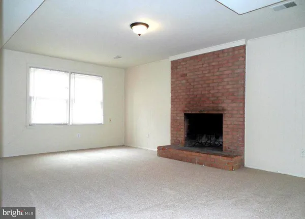 a living room with a fireplace and a ceiling fan