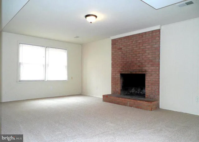 a living room with a fireplace and a ceiling fan