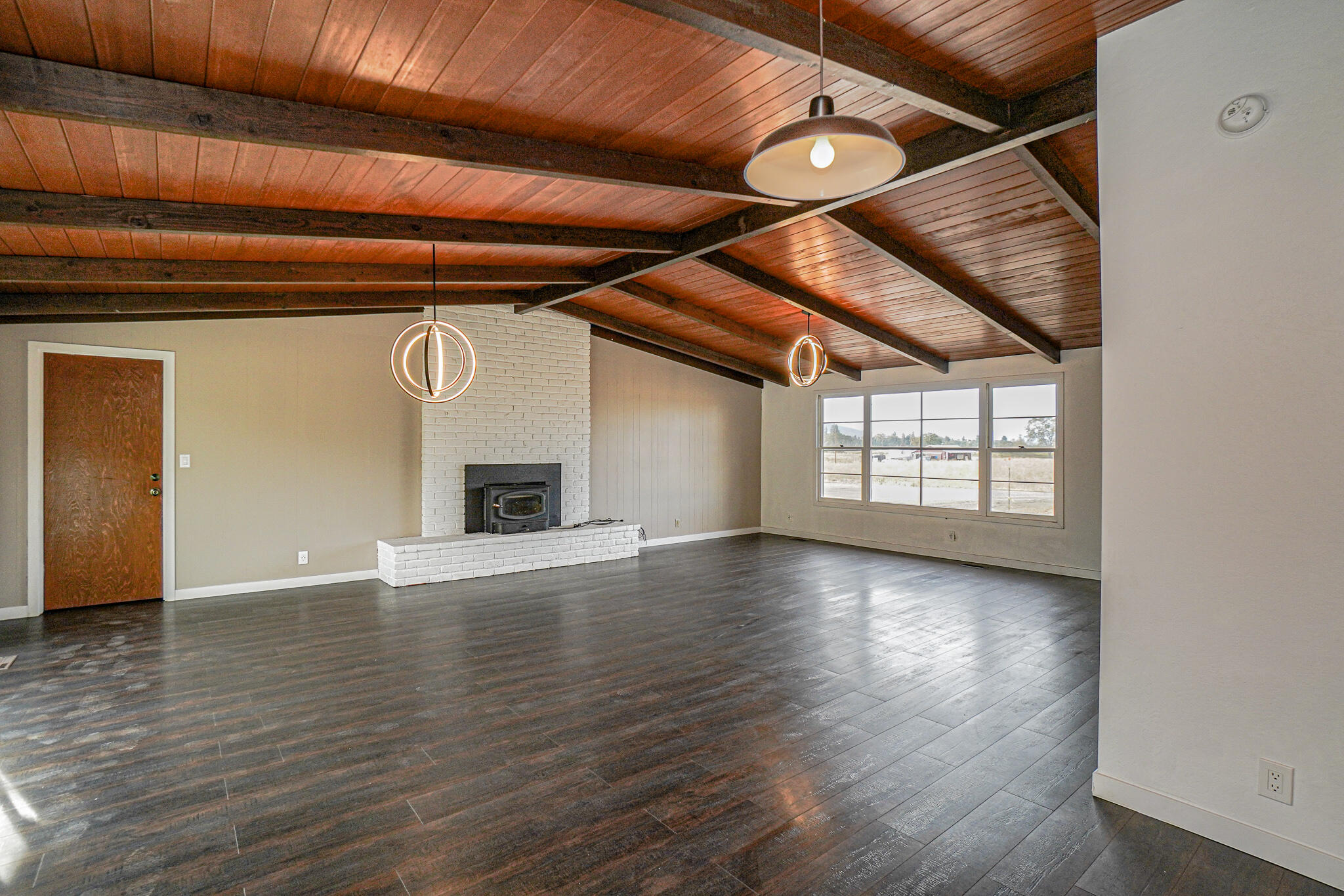 674 Oak Grove Road Medford, OR 97501 - Photo 6 of 47 Living room with hardwood floors, wood-beam vaulted ceiling and brick fireplace.