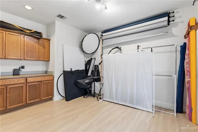 a very nice looking room with wooden floor and cabinets