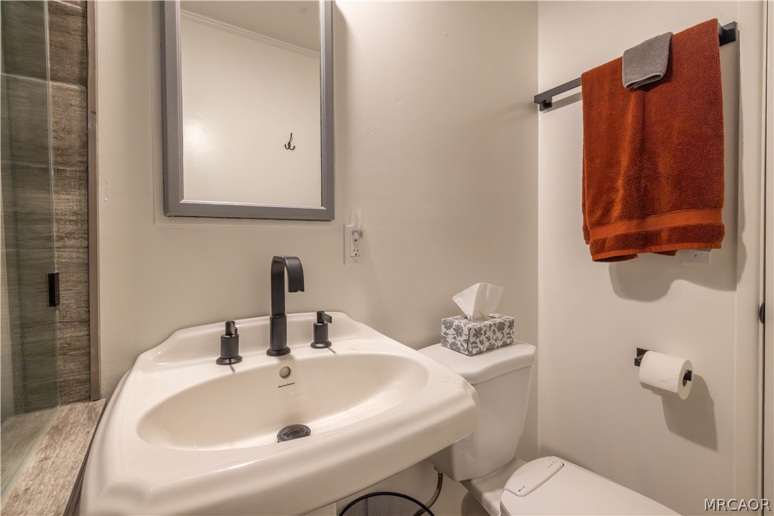 773 Sunset Lane Sugarloaf, CA 92386 - Photo 19 of 33 a bathroom with a sink a toilet and mirror