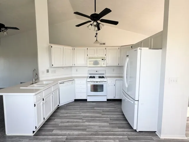 a kitchen with white cabinets and white appliances