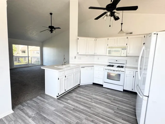 a view of empty room with wooden floor and windows