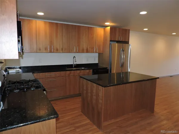 a kitchen with granite countertop a stove and a refrigerator