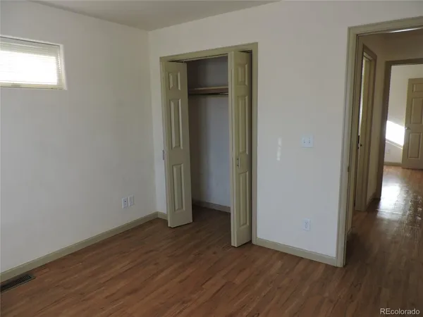 an empty room with wooden floor and closet