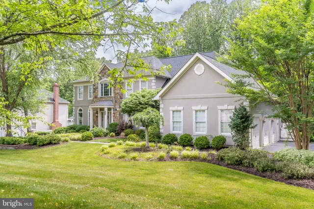 a front view of a house with a yard and trees