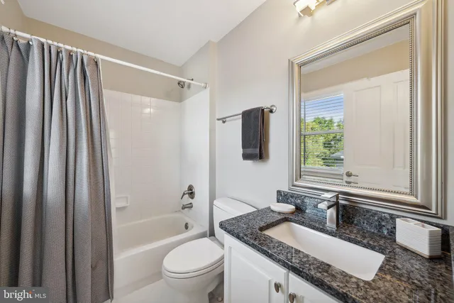 a spacious bedroom with a bed a couch and large window