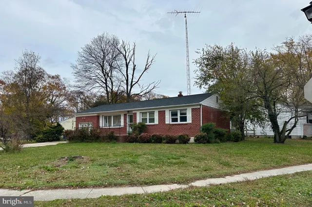 a front view of a house with a garden and trees