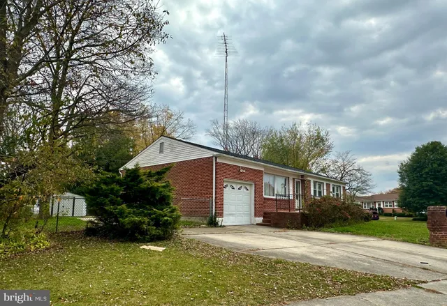 a view of a house with a big yard plants and large trees