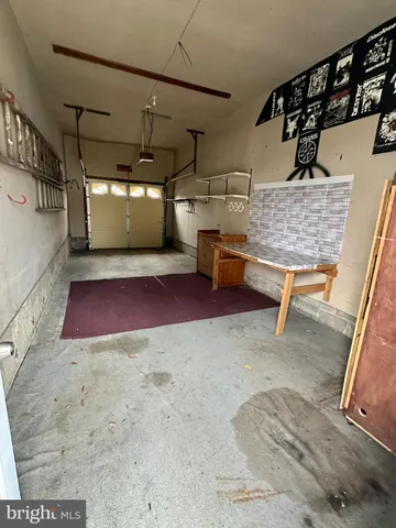 a view of a yard in front of a house with plants and large tree
