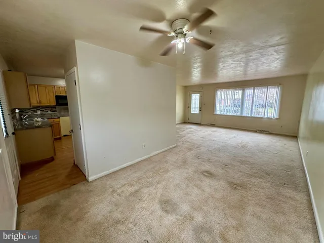 an empty room with windows and ceiling fan view