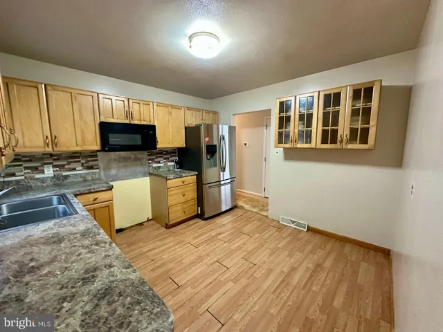 a kitchen with stainless steel appliances granite countertop a refrigerator stove microwave and sink