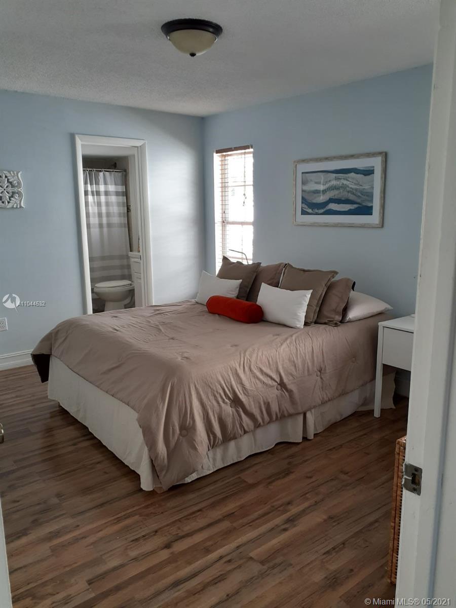 1404 Southwest 104th Court, Unit 89B Miami, FL 33174 - Photo 13 of 29 a bedroom with a bed and wooden floor