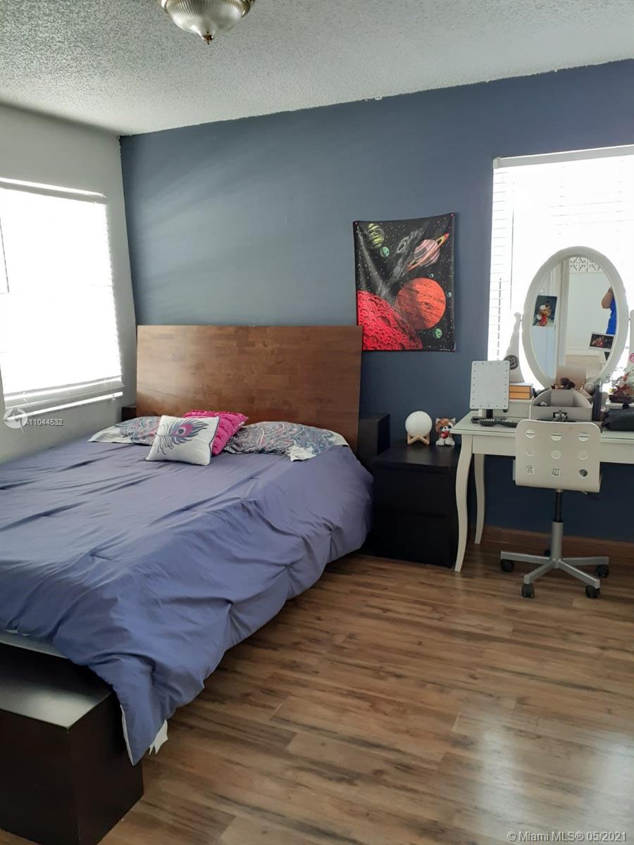 1404 Southwest 104th Court, Unit 89B Miami, FL 33174 - Photo 16 of 29 a bedroom with a bed window and table