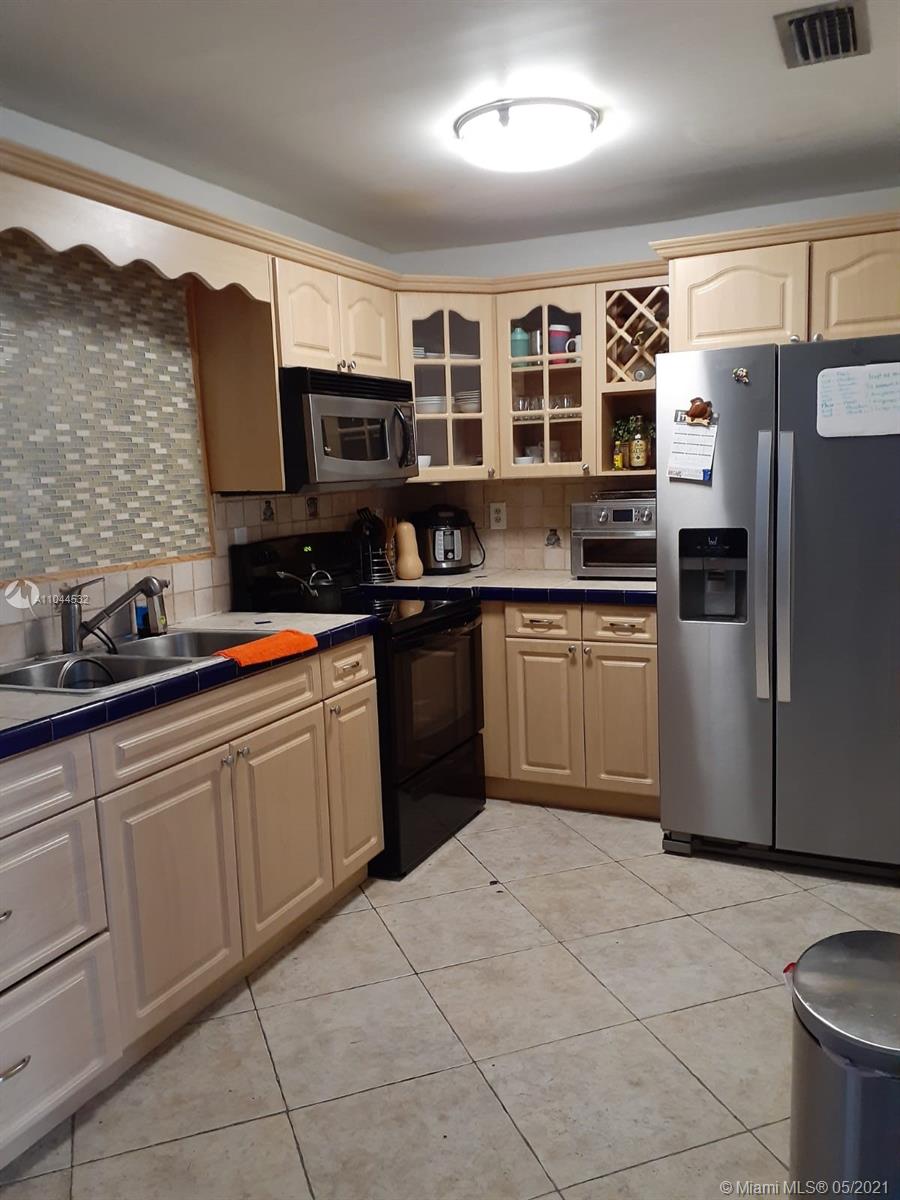 1404 Southwest 104th Court, Unit 89B Miami, FL 33174 - Photo 18 of 29 a kitchen with stainless steel appliances granite countertop a stove sink and cabinets